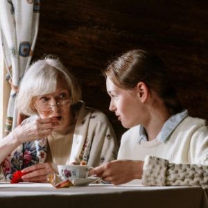 Femme senior avec sa petite fille prenant le thé pour le gouter.